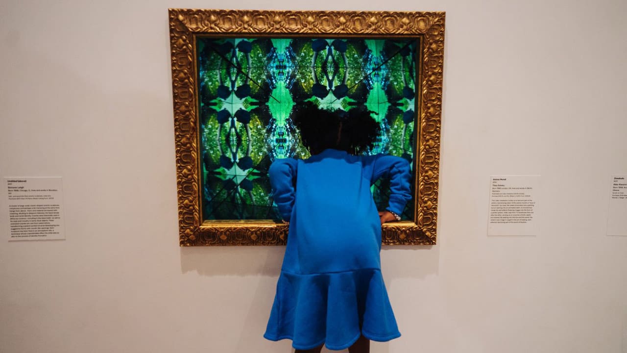 girl leaning into interactive exhibit at newark museum of art