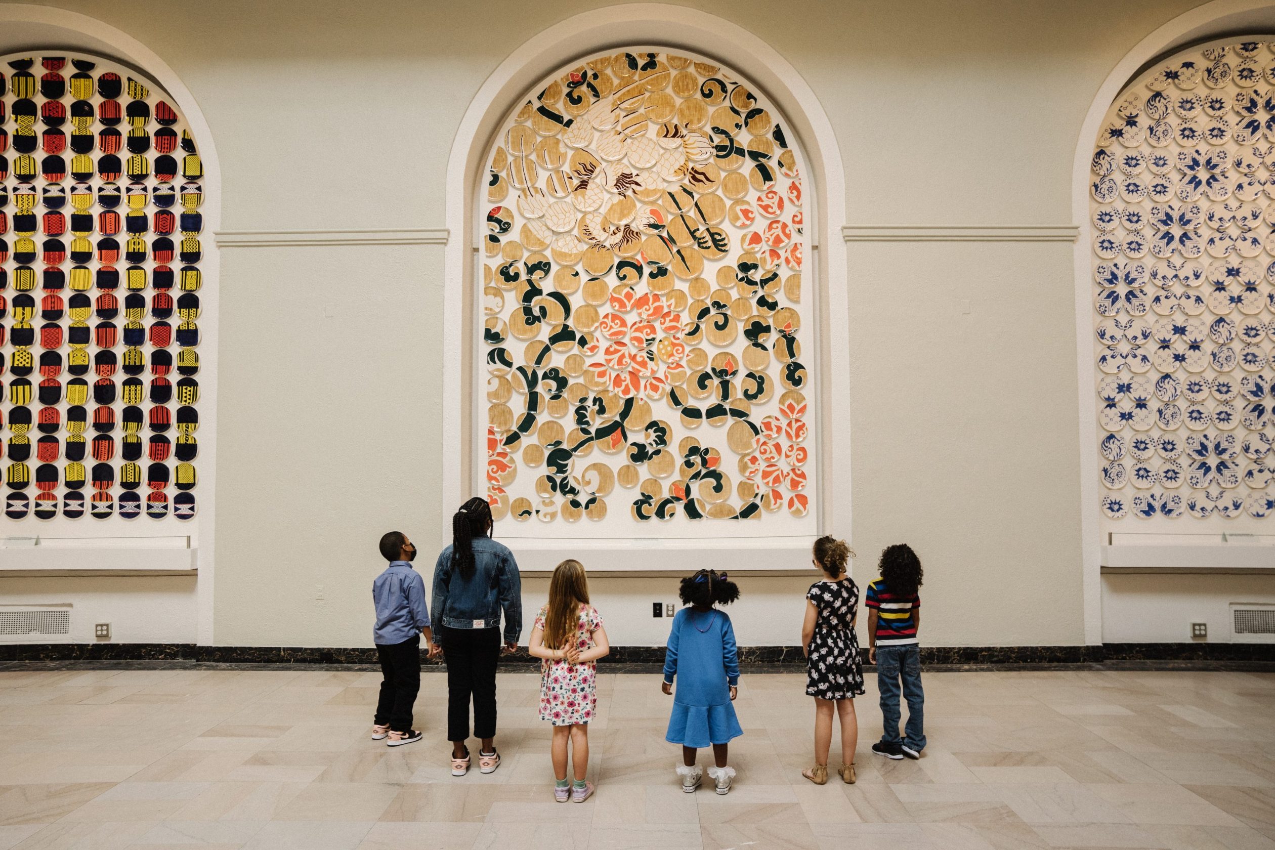 group of children staring at an art installation