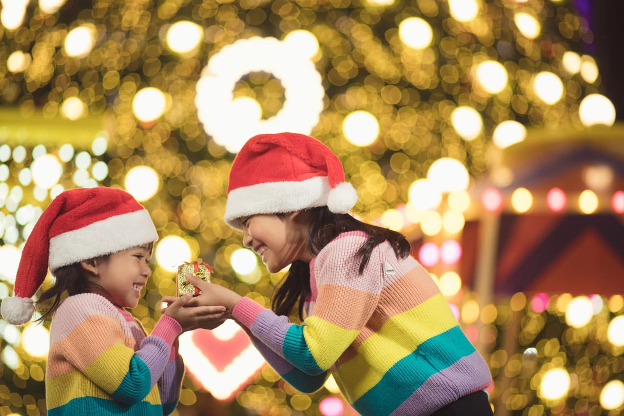 Merry Christmas happy children with a magic gift at home near Christmas tree