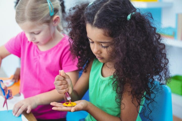 Girls making arts and crafts together at their desk