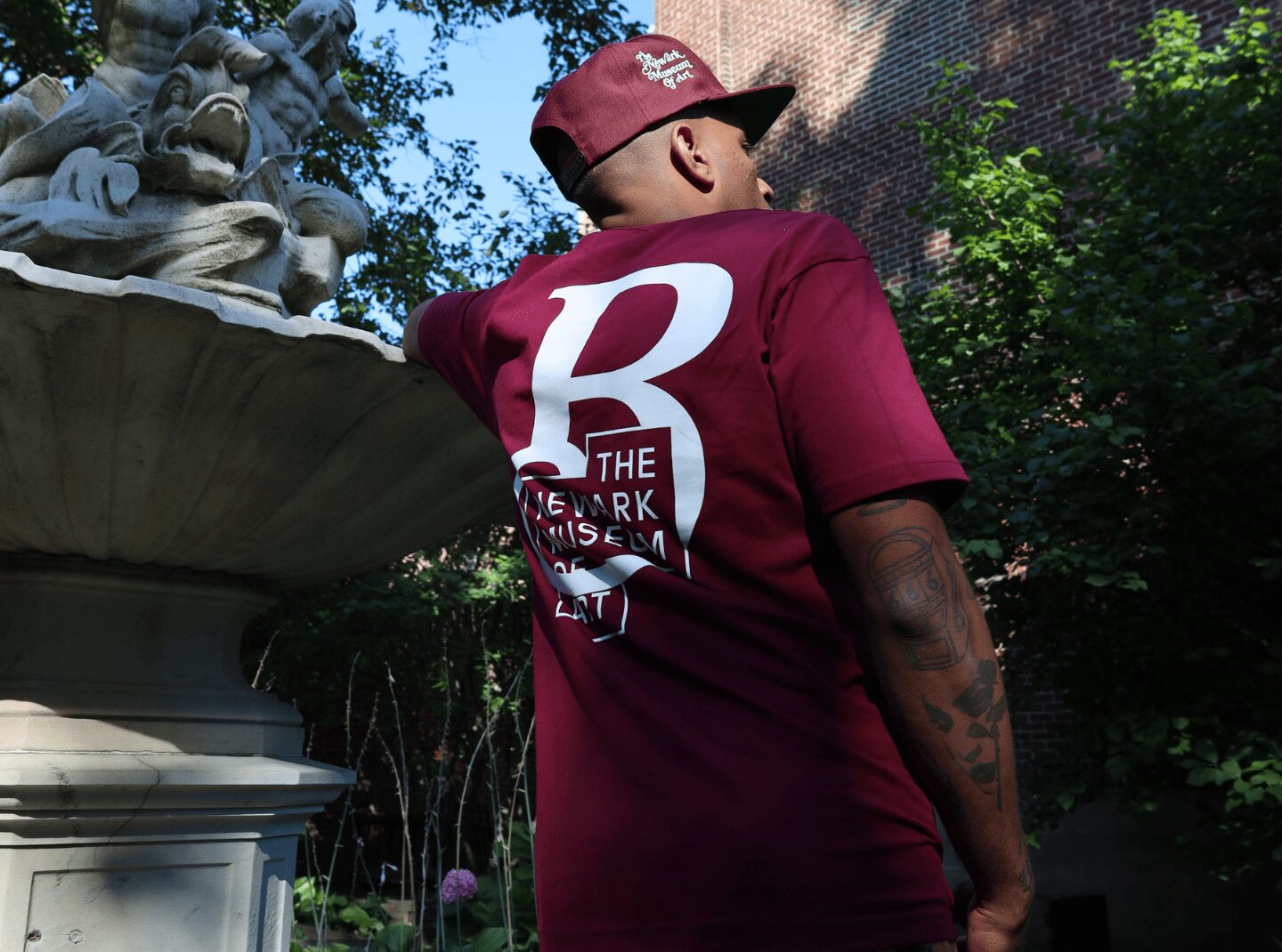 BrownMill NMOA Newark Museum of Art back of man by fountain t-shirt cap
