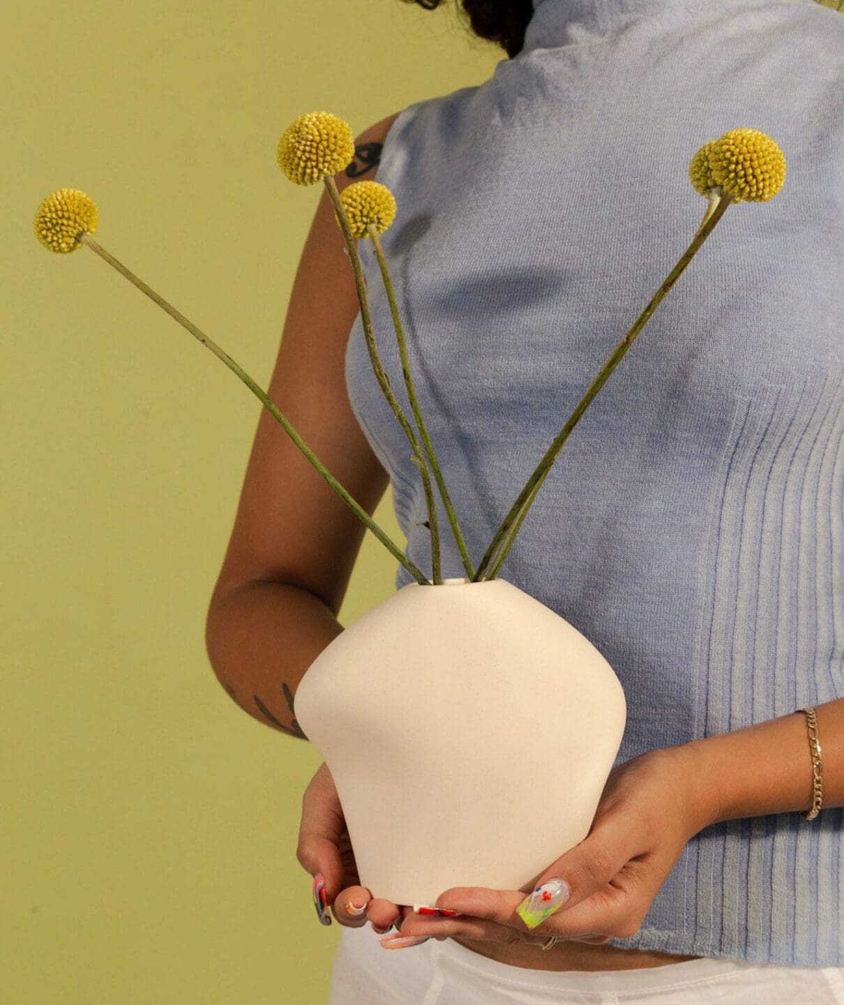 homa studios trunk show woman holding flower vase