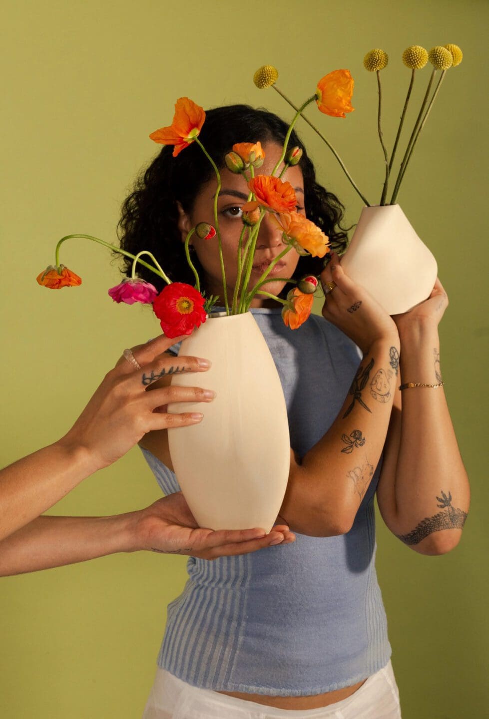 homa studios trunk show woman holding up flower vases